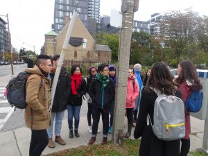 A group of students stands across the street from a church