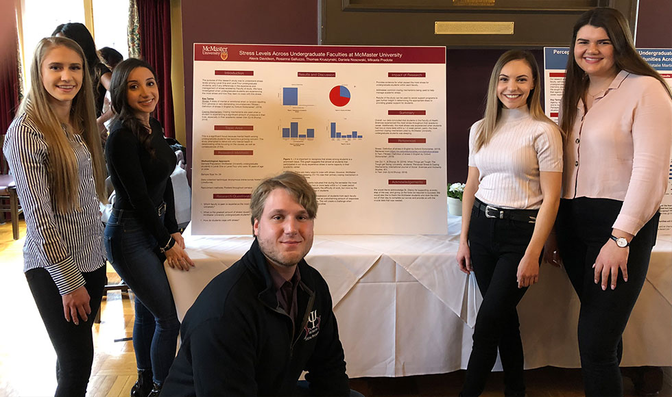 A group of social psychology students presents their research capstone project poster
