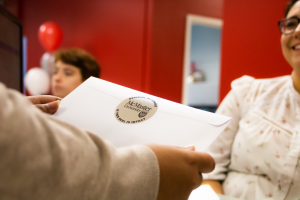 A woman is handed an envelope in McMaster's registrar's office