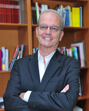 michael dear smiling in front of a bookcase