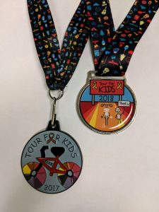 Two medals, designed by children, hang on their ribbons