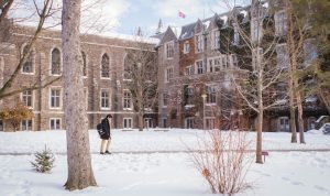 A student walks on a snowy McMaster campus