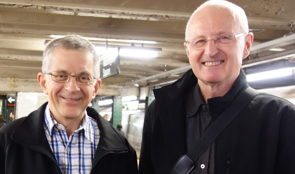 Two men smiling at the camera.