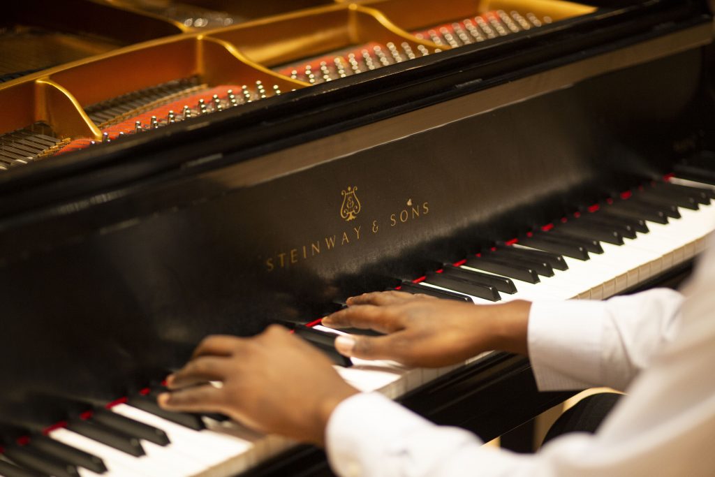 A man's hands on a Steinway piano