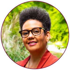 A headshot of Clare Warner. She is wearing glasses and smiling at the camera