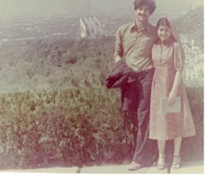 A photo of a man and woman standing close together and smiling.