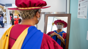 Juliet Daniels wearing her red, blue and yellow convocation gown and hood 