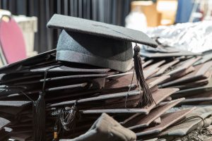 A pile of mortarboards on a table