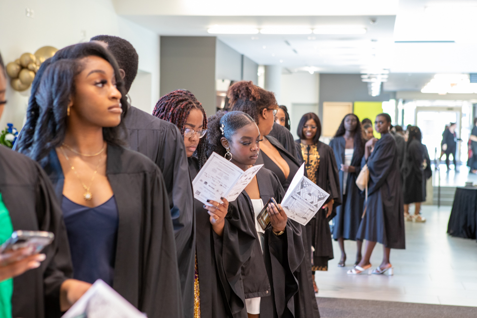 A lineup of students in their graduation gowns