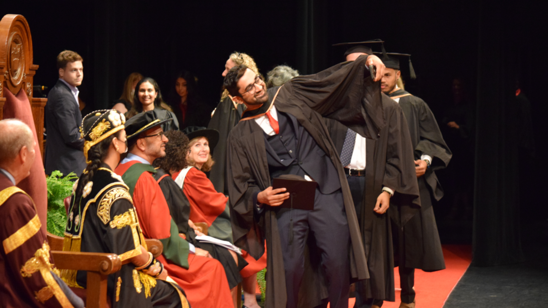 A DeGroote School of Business grad poses for a selfie with Dean Khaled Hassanein