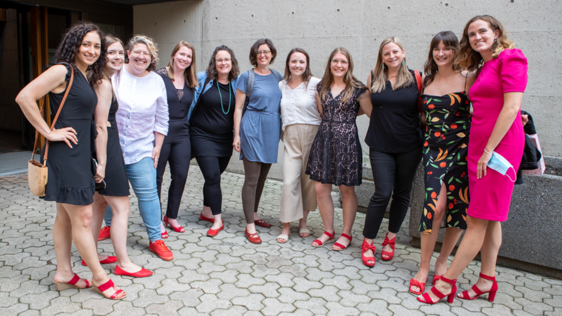 A group of midwives with red shoes on pose for a picture