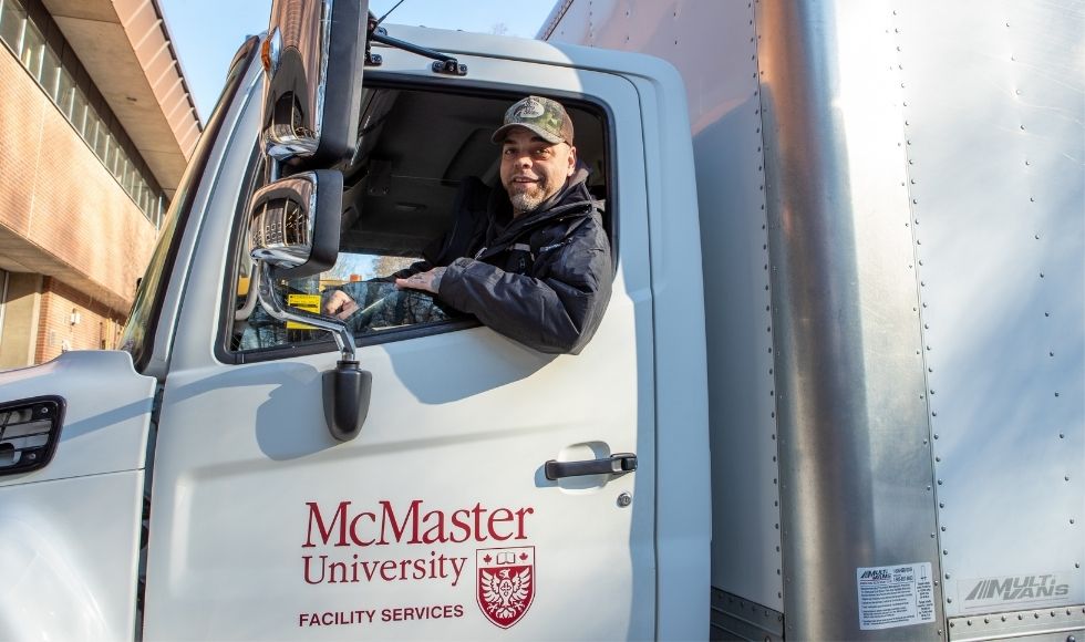 Gary smiling out from the window of the driver's seat of a McMaster Facility Services truck.