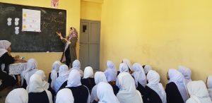 Marjan Alipur standing in a classroom teaching a group of young girls 