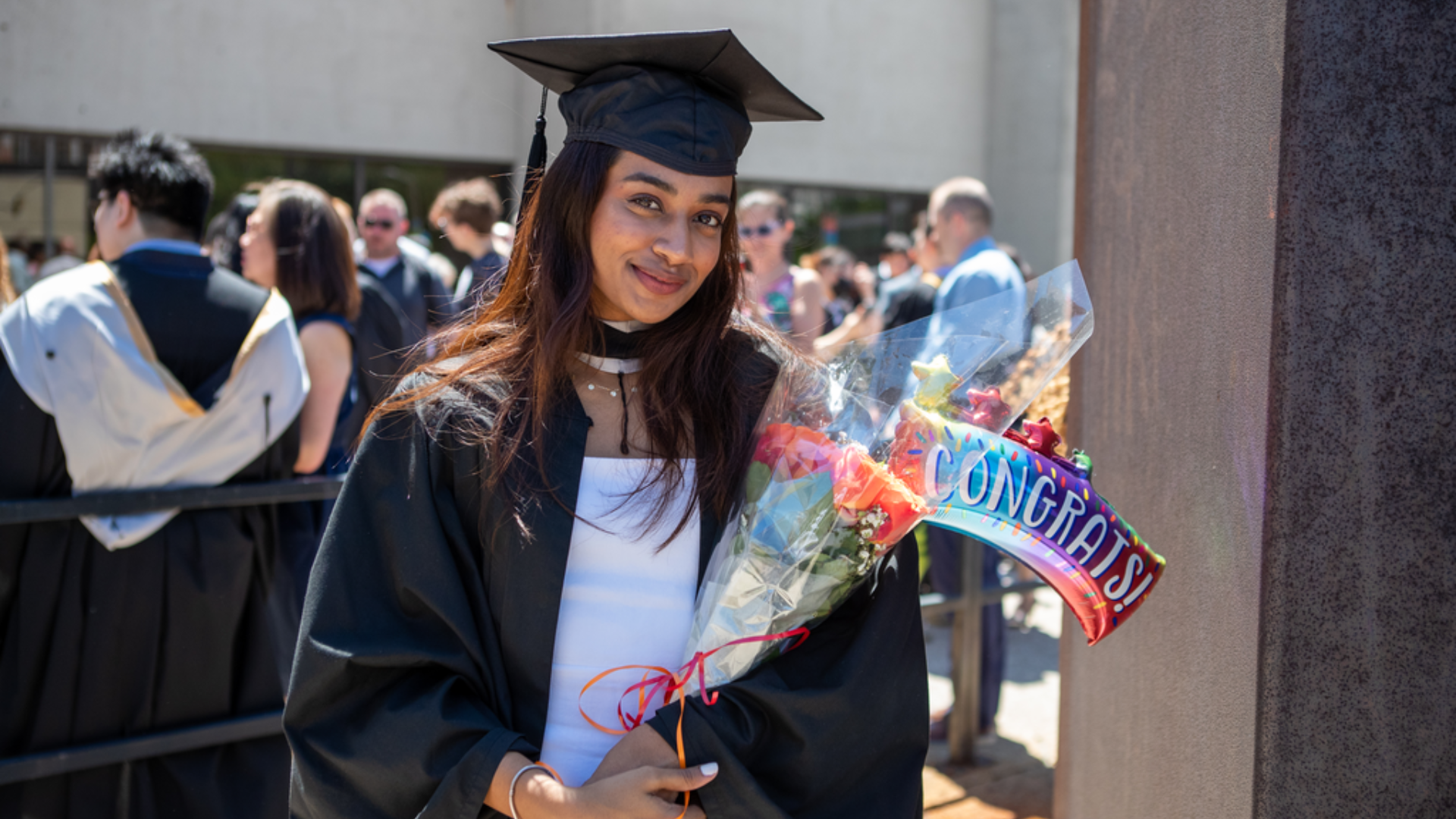 Sadiyah Manidhar poses for a photo with a bouquet of flowers in their arms