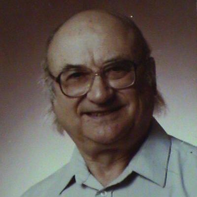 professor in golf shirt wearing glasses and smiling at camera