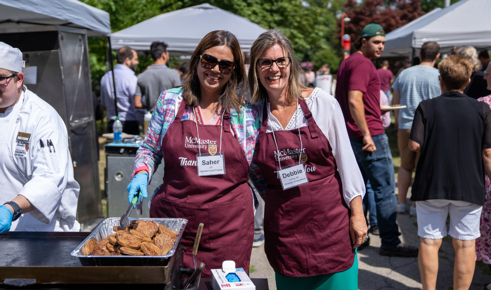 Saher Fazilat, Vice-President, Operations and Finance, and Debbie Martin, Vice-President (acting), Advancement, hand out food to staff.