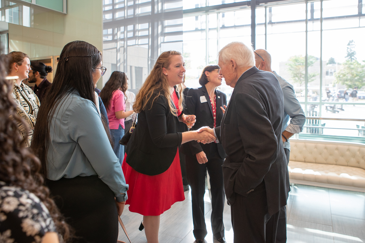 A student shakes hands with Lynton Wilson. 