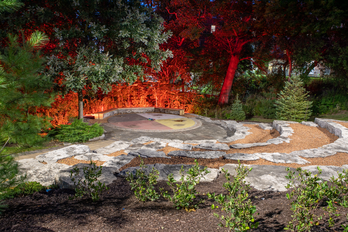 Orange lights illuminate one end of the Indigenous circle.