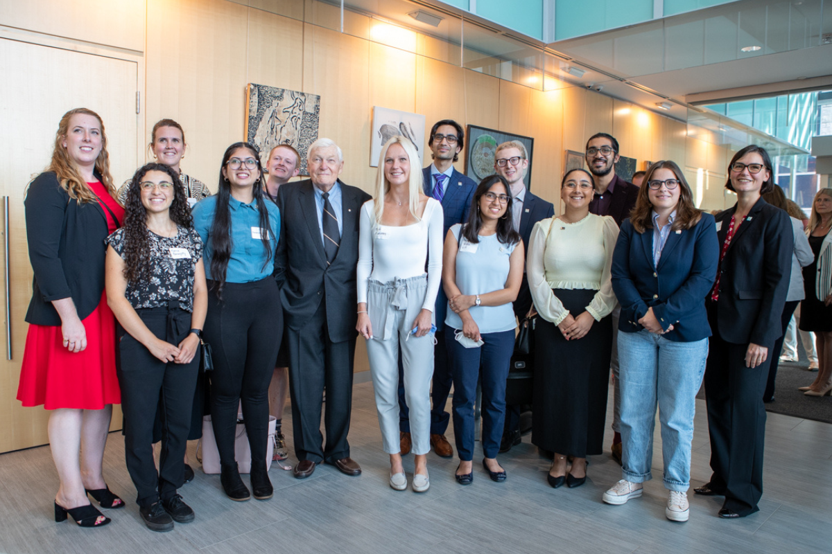 A group of students pose for a photo with Lynton Wilson. 