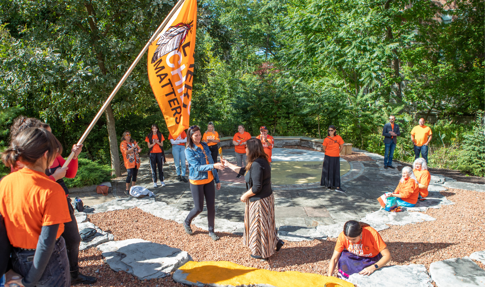 People painting one of the large stones at the Indigenous Circle.