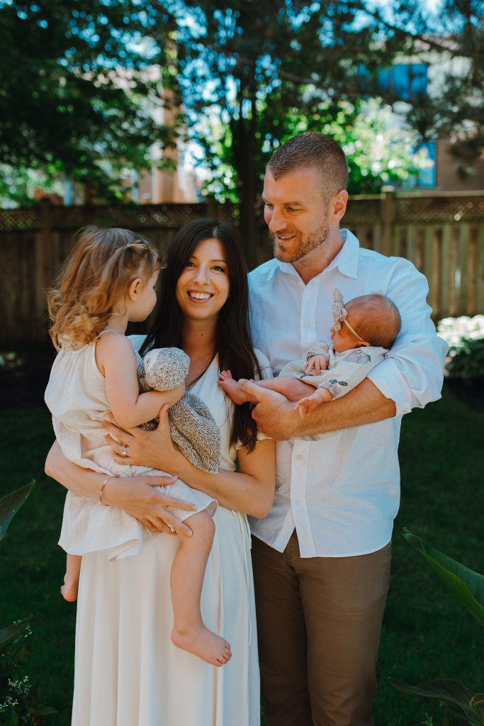 A photo of a woman holding a toddler and a man holding a baby