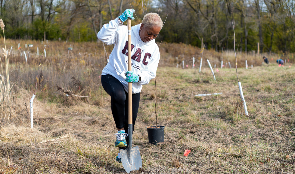 Juliet Daniel puts her weight on a shovel as she digs in the ground.
