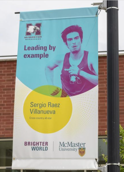 A lamppost banner featuring Sergio Raez-Villanueva running that reads 'leading by exmaple'