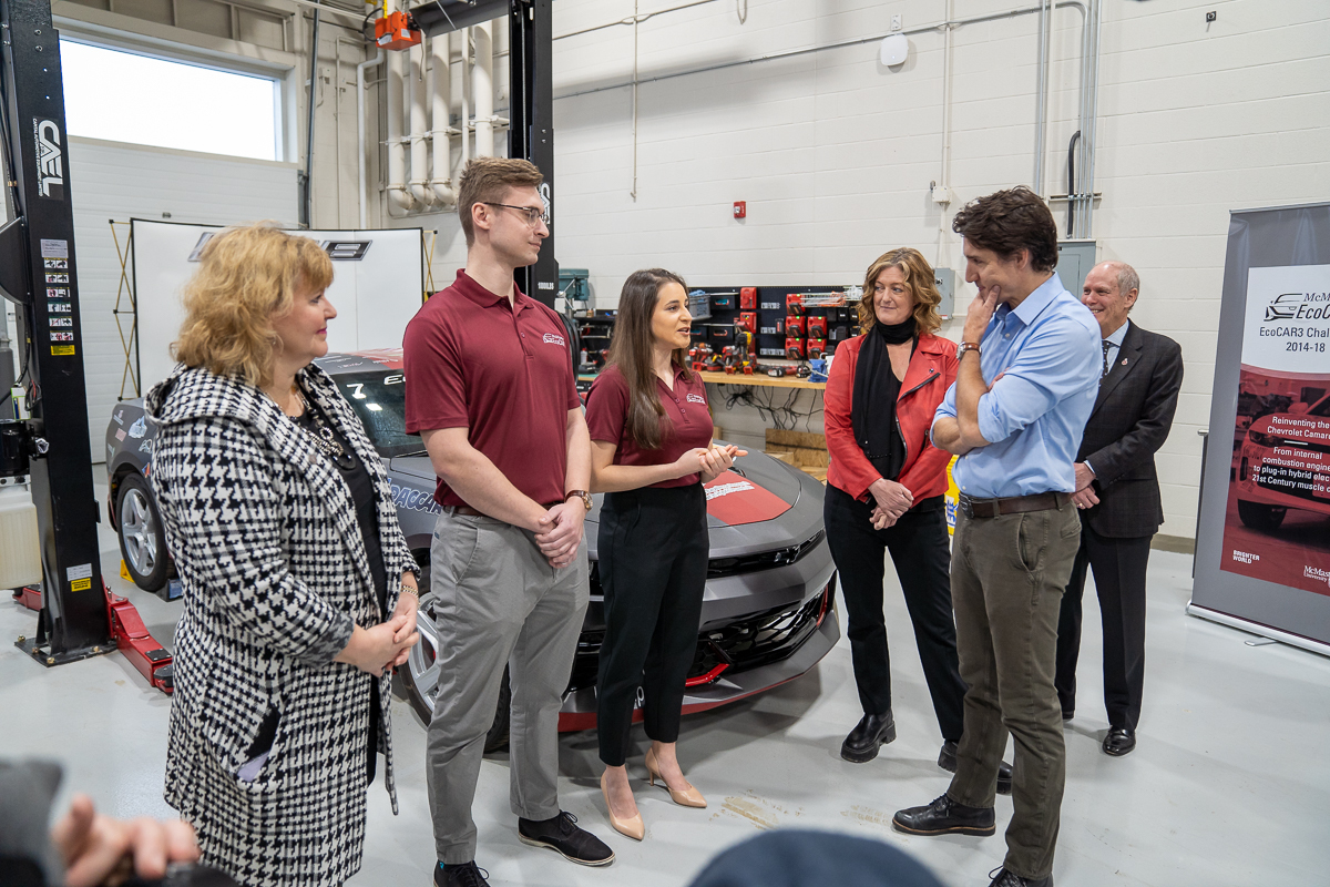 Two members of the EcoCar Challenge talk with the Prime Minister in front of the vehicle, watched by local MP Lisa Hepfner, David Farrar and Provost Susan Tighe. 