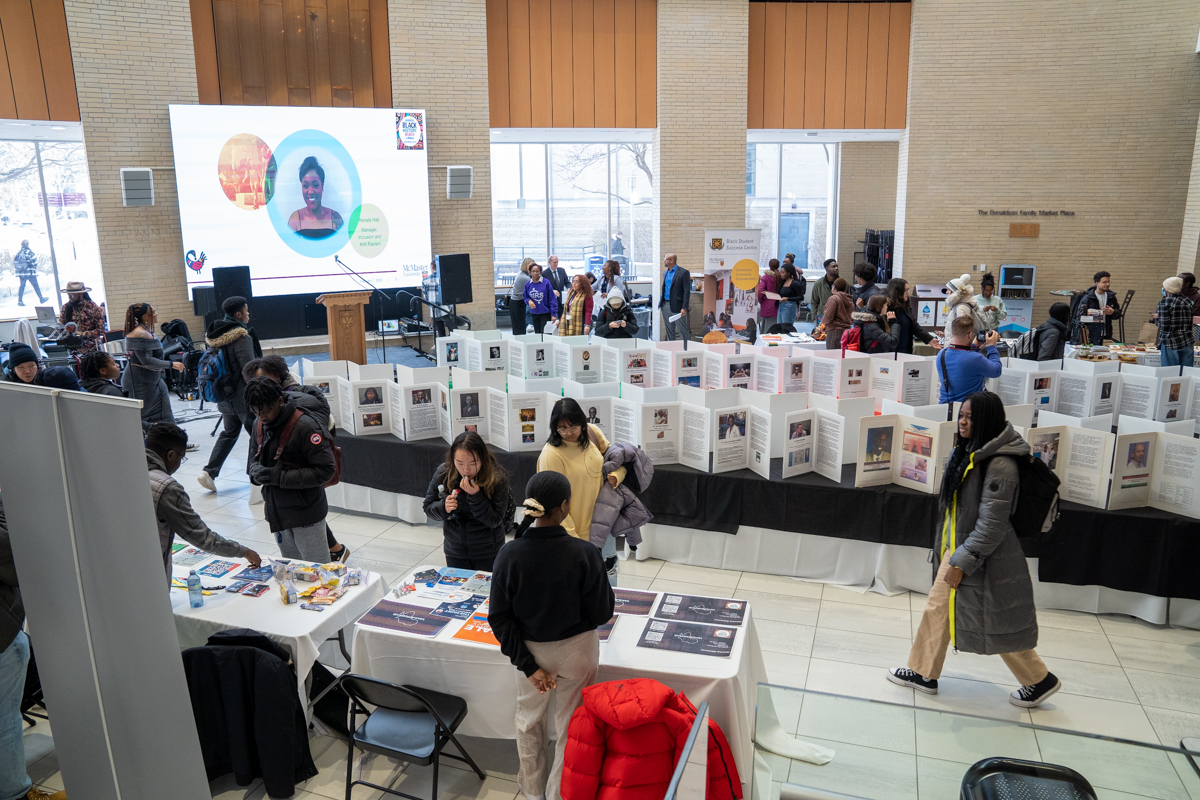 A group of students and attendees walk through the Black Expo