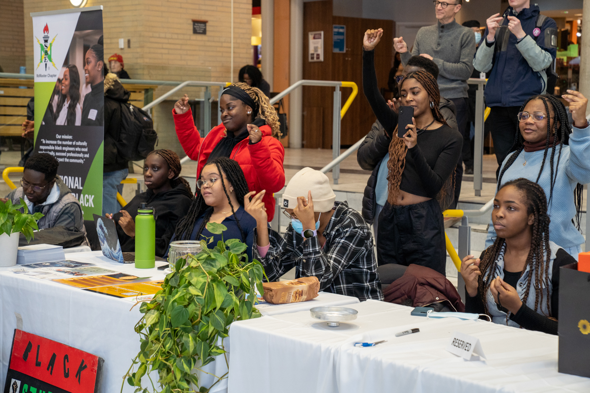 Students snap along to a performance of spoken word poetry