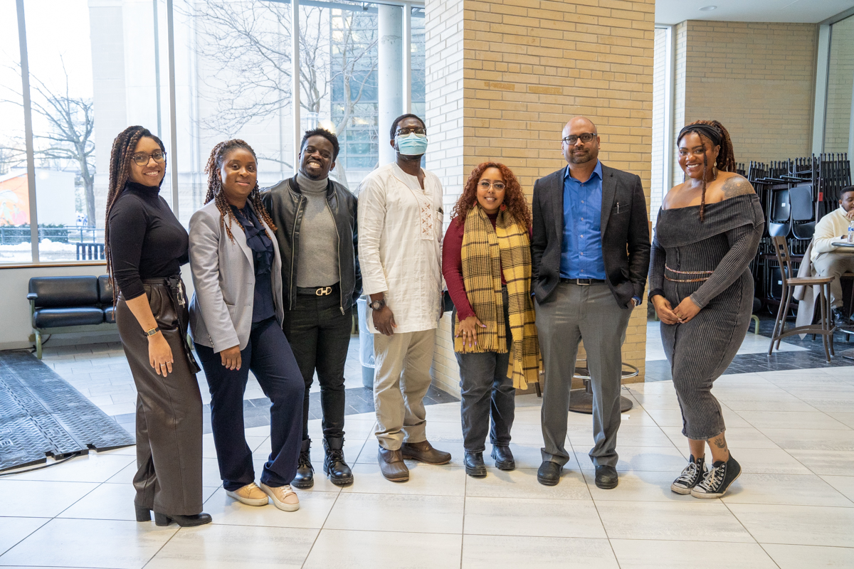 A group of speakers and event organizers pose for a photo