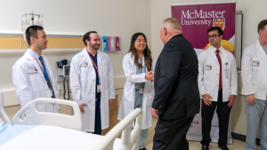 Doug Ford shaking hands with a group of people wearing labcoats