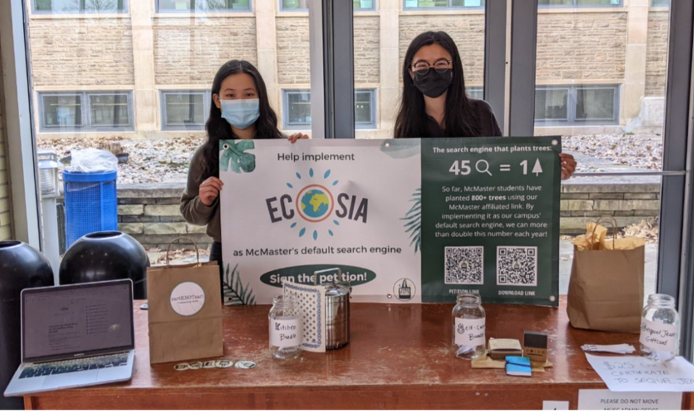 Two McMaster students holding up a sign advertising the Ecosia browser