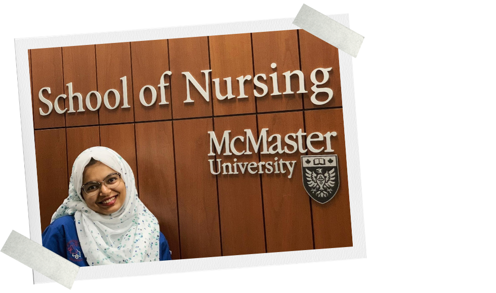 Salwa in her blue scrubs standing in front of the McMaster School of Nursing sign.