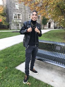 Ian-Carlo wearing all black clothes standing in front of a bench at McMaster