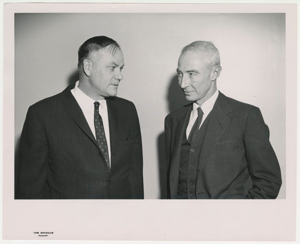 Two men in suits looking at one another.