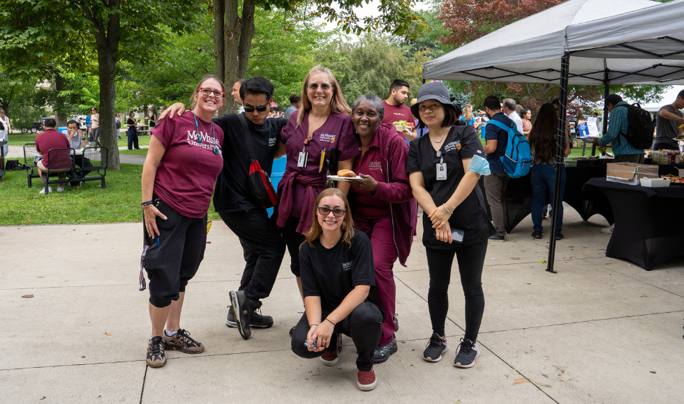 A group of employees strikes a pose at the employee picnic.