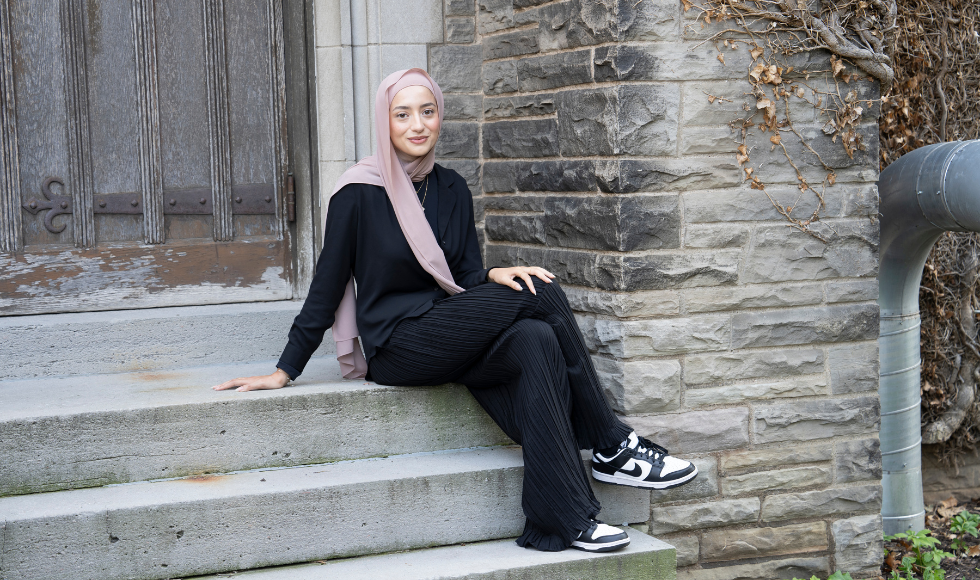 Reem Tehfe sitting on concrete steps leaning back on one arm 