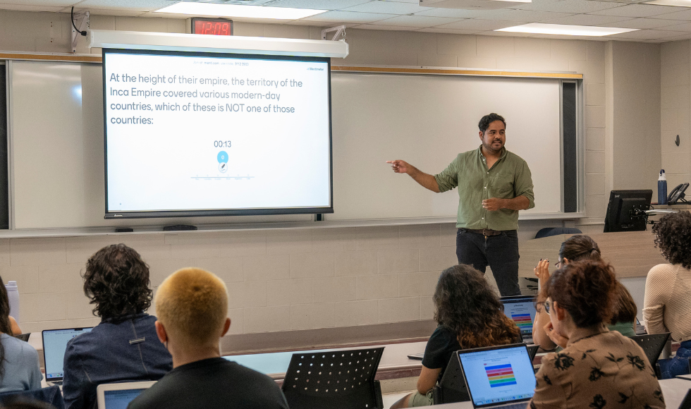 A professor teaching at the front of a classroom 