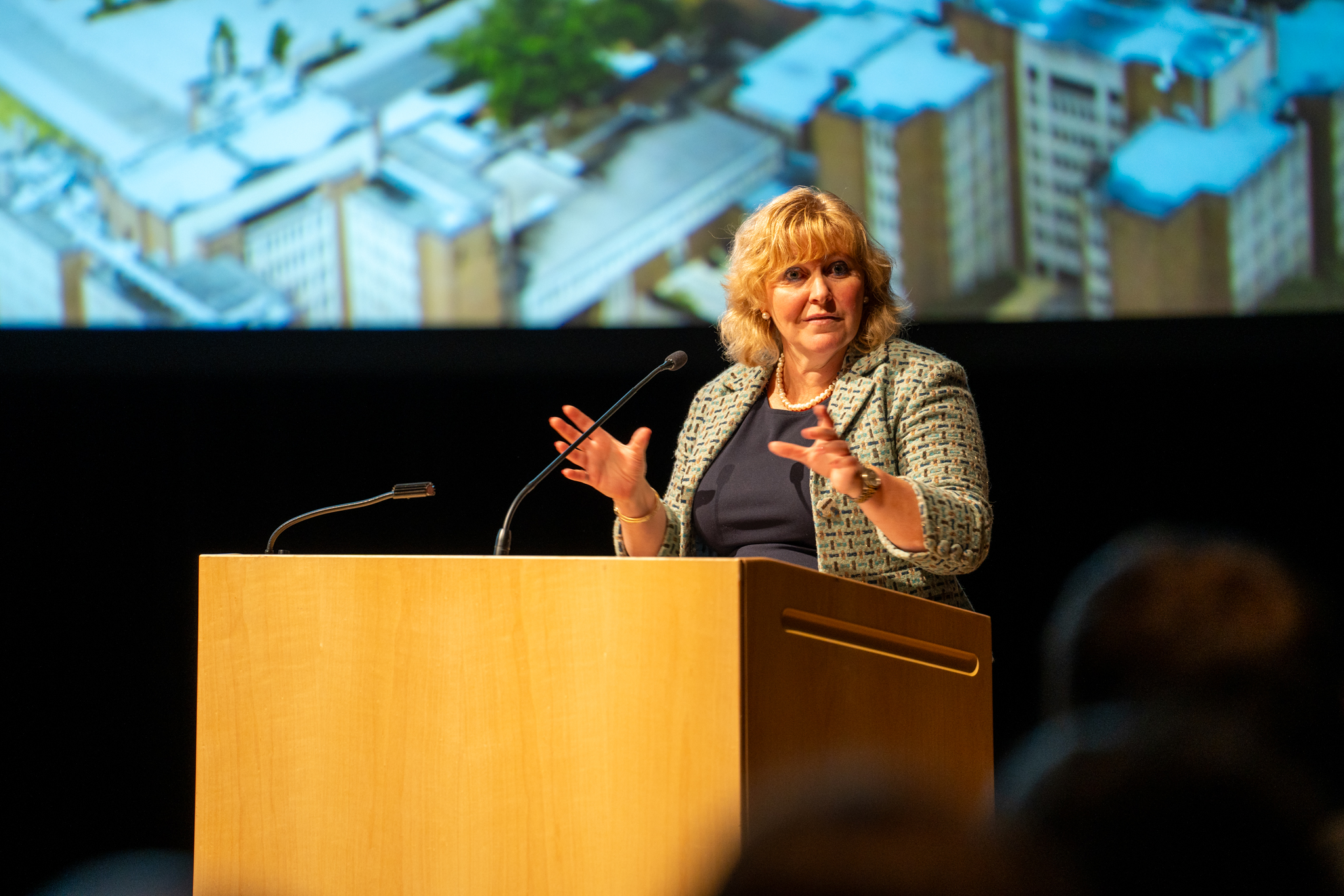 Susan Tighe speaking into a microphone at a podium