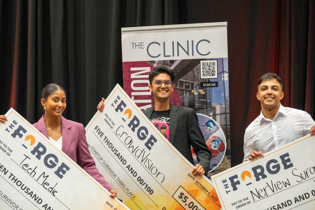 Startup Survivor top 3 finalists Shania Bhopa, Ibrahim Iftikar and Mann Parikh hold up their giant award cheques.