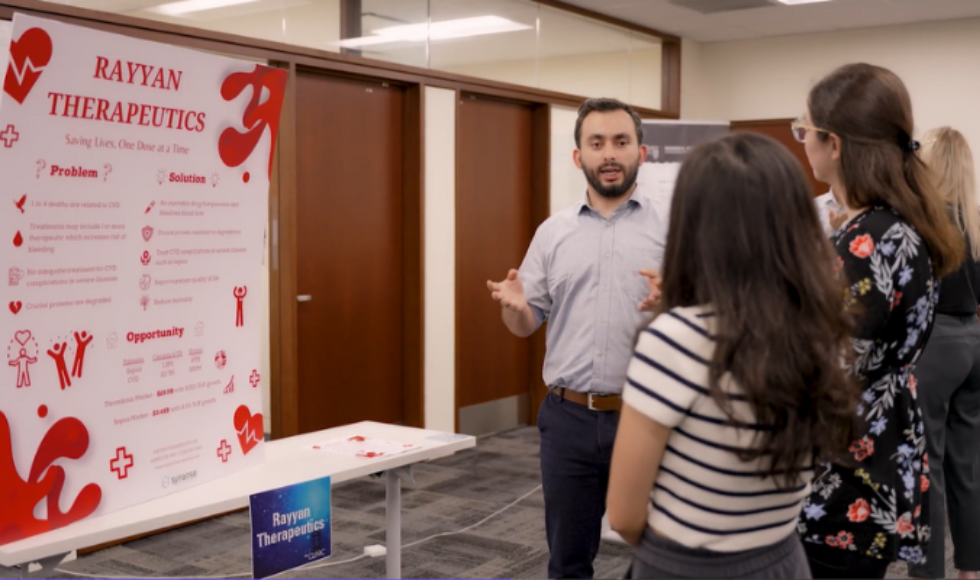 Hasam explaining his work to people.