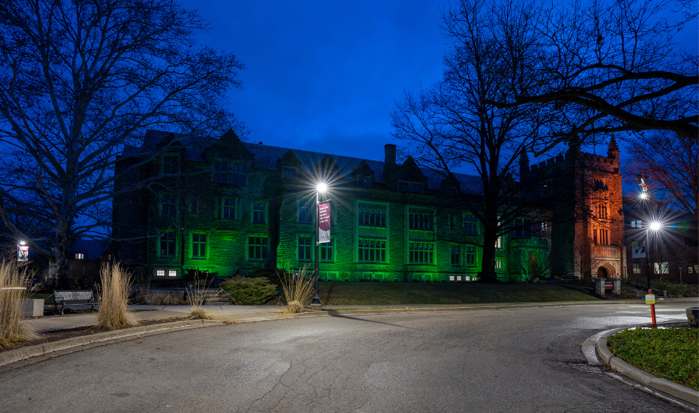 McMaster’s University Hall illuminated in green lights 