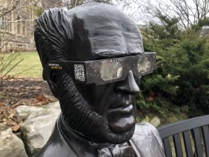 A pair of solar eclipse glasses on the Senator McMaster statue