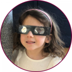 A child wearing eclipse glasses 