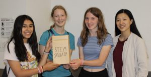 Four girls holding up a project that says "STEM squad"