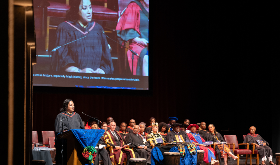 Nigela Purboo speaking at the lecturn on stage during convocation.