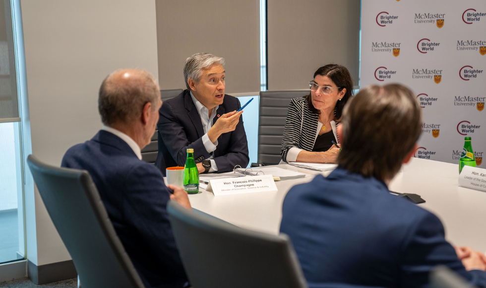 Four people in discussion while seated at the end of a boardroom table 