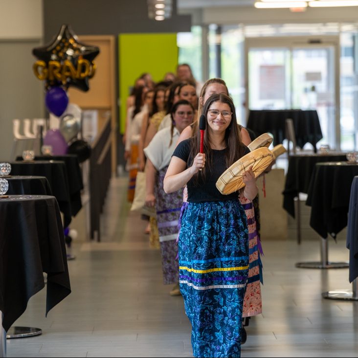 A line of students led by students playing Indigenous drums