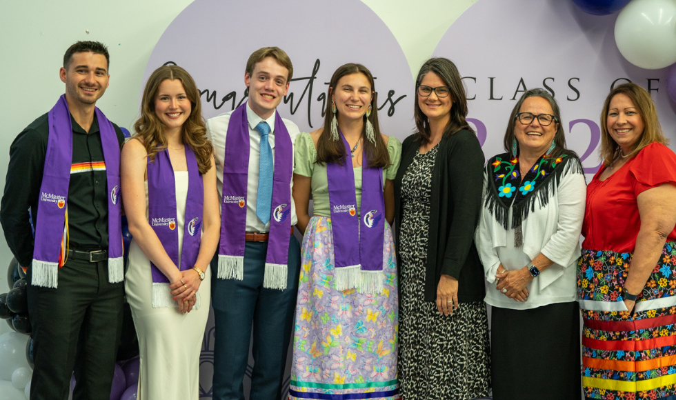 4 Grads and 3 professors pose for a smiling picture at the INdigenous graduation celebration